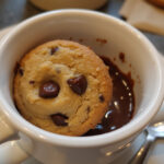 Delicious cookie in a mug with melted chocolate chips.