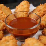 Homemade Raising Cane's Sauce served with golden chicken tenders, perfect for dipping.