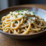 Finished French Onion Pasta garnished with thyme and Gruyère cheese.