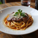 Perfectly cooked steak pasta with parsley and parmesan cheese, ready to eat.