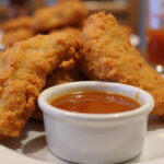 Juicy Raising Cane's Sauce served with chicken tenders.