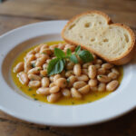 Finished butter bean recipe served with olive oil, herbs, and crusty bread.
