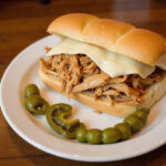 Mississippi Chicken sandwich with provolone cheese and pepperoncini peppers, ready to eat.