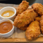 Homemade Raising Cane's sauce with crispy chicken tenders, perfect for dipping.