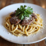 Finished steak pasta dish with parsley and Parmesan cheese.