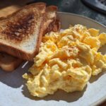 A plate of fluffy scrambled eggs and golden toast, perfect for easy breakfast recipes.