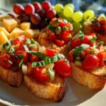 Close-up of fresh bruschetta with cherry tomatoes and basil, served with cheese cubes and grapes as New Years appetizers.