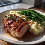 A plate of roasted pork, mashed potatoes, and green beans, perfect for New Years dinner ideas.