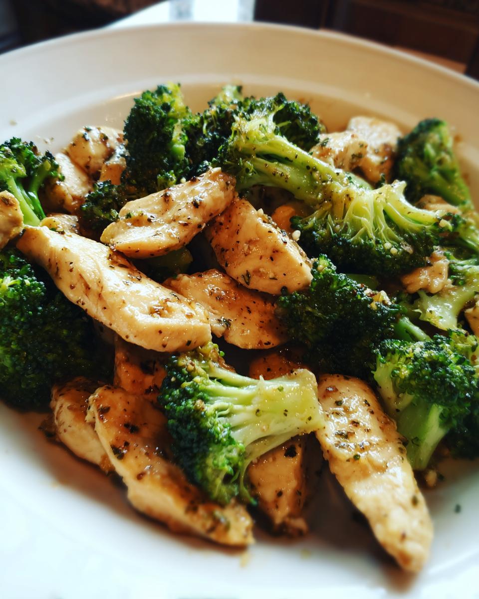 Plate of easy healthy dinner recipes featuring chicken slices and broccoli florets seasoned and cooked.