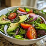 A refreshing bowl of avocado, cherry tomatoes, and red onion salad, perfect for healthy lunch ideas.