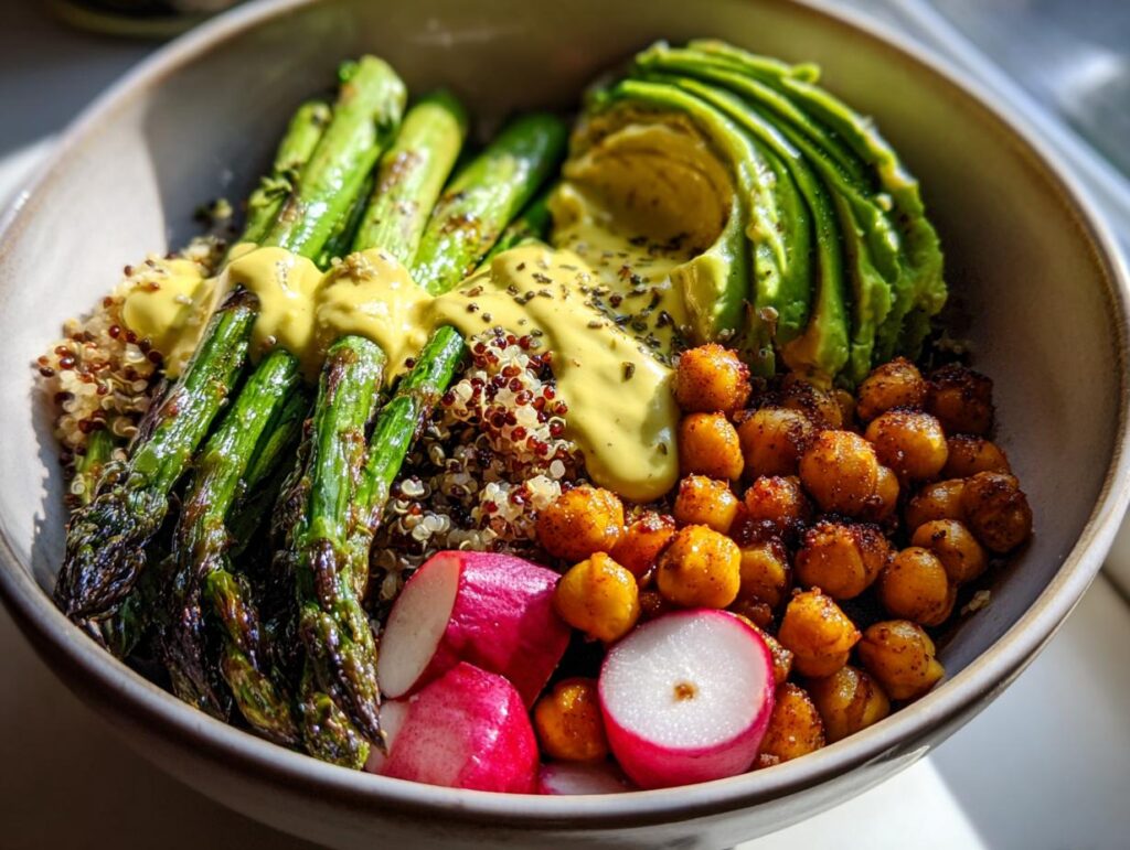 Buddha bowl spring recipes featuring grilled asparagus, avocado, chickpeas, radishes, quinoa, and mustard sauce.