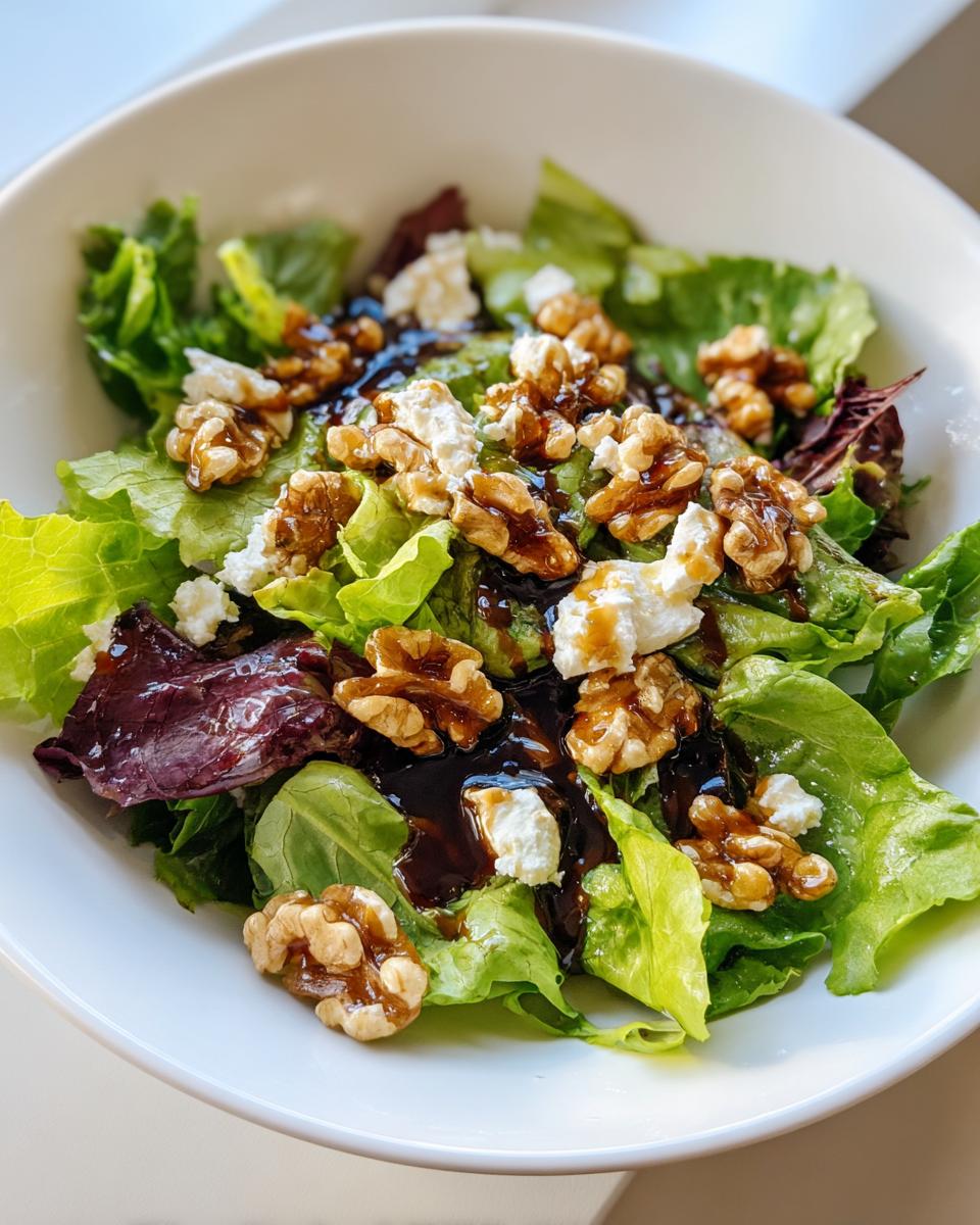 Bowl of salad with goat cheese, walnuts, mixed greens, and balsamic dressing