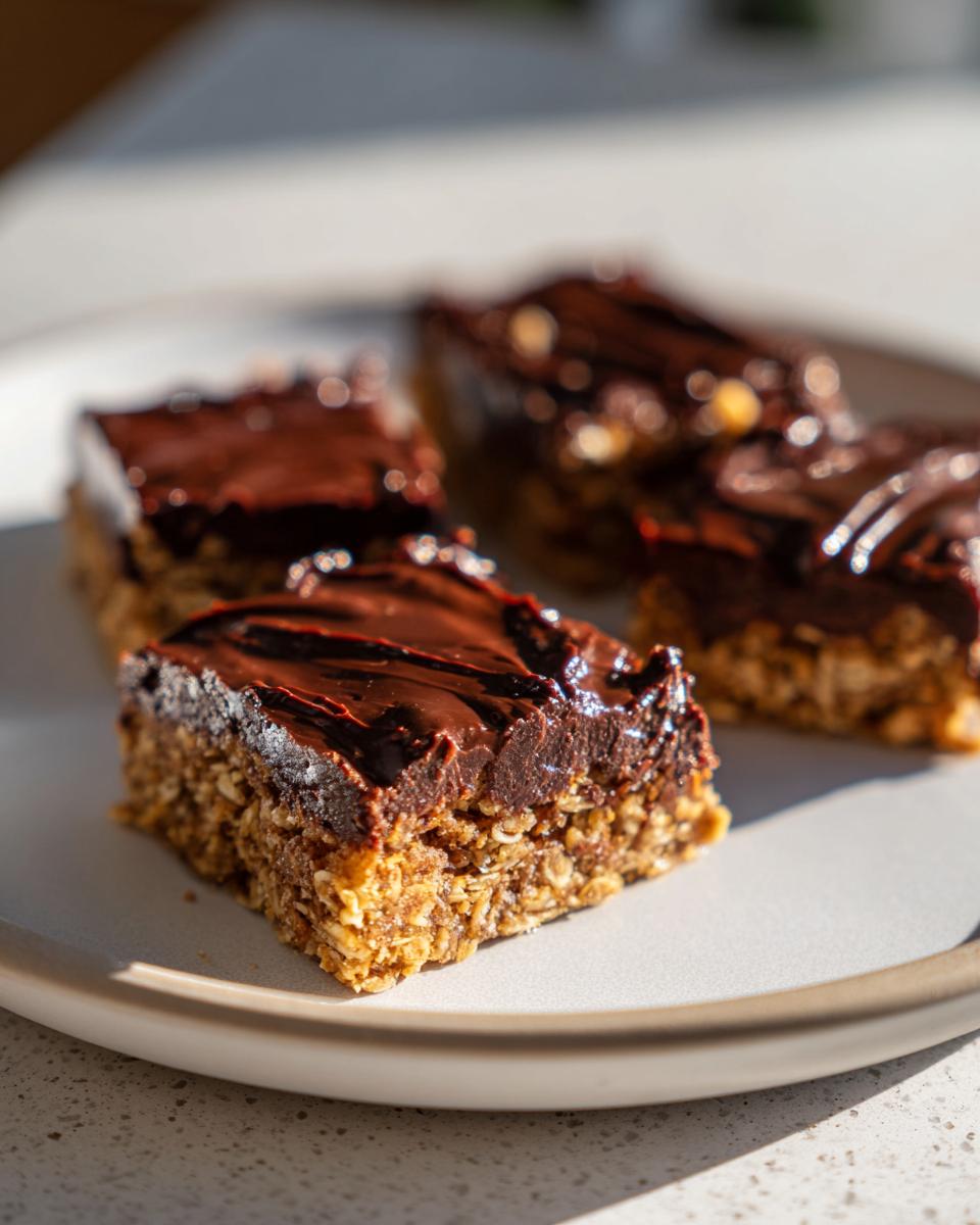 Close-up of no bake dessert ideas easy chocolate oat bars on a white plate.