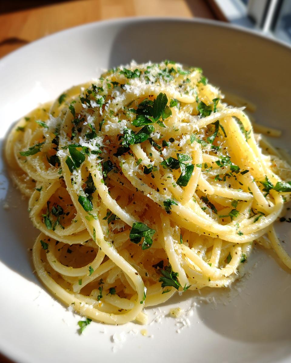 Plate of spring lemon pasta recipes with spaghetti, grated cheese, and chopped parsley.