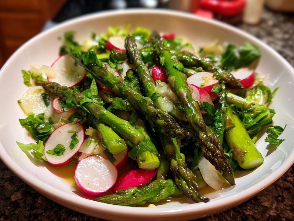 Bowl of fresh asparagus and radish salad with greens, perfect April brunch side dishes