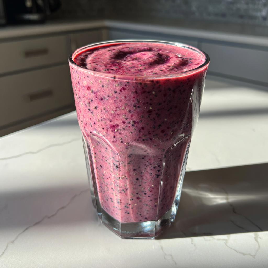 Close-up of a berry smoothie in a clear glass on a kitchen counter for easy smoothie breakfast recipes