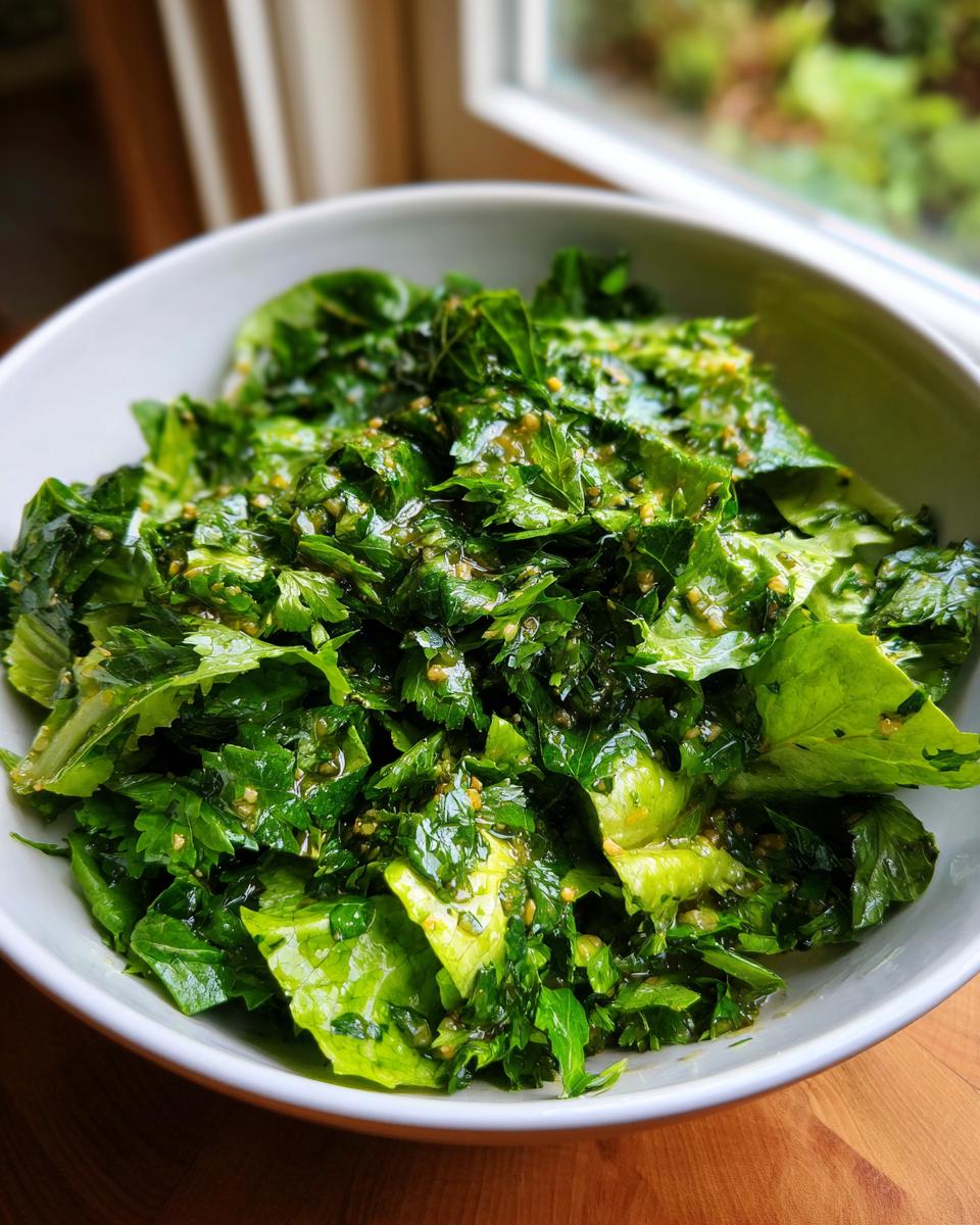 Bowl of fresh green herb salad with dressing, perfect for spring fresh herb recipes