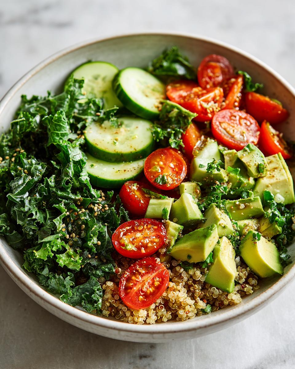 Healthy grain bowl recipes with quinoa, kale, cucumber, cherry tomatoes, and avocado in a bowl.