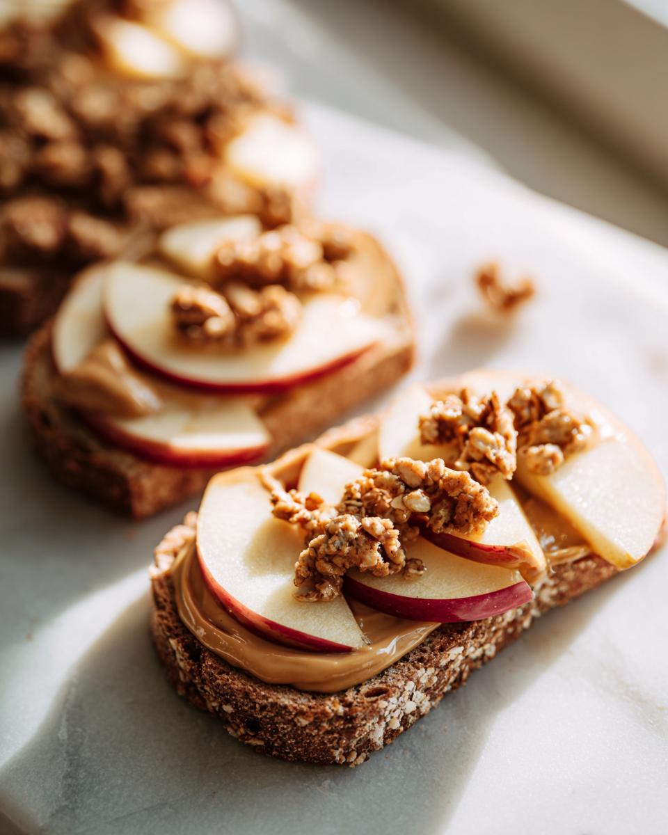 Whole grain toast topped with peanut butter, apple slices, and granola for quick after school snack ideas