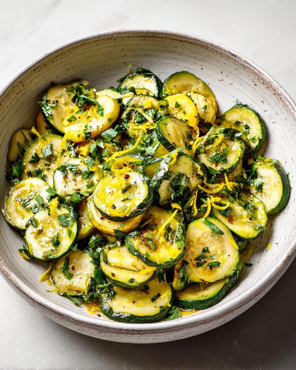 Bowl of sautéed zucchini slices with fresh herbs and lemon zest, a spring zucchini recipes dish