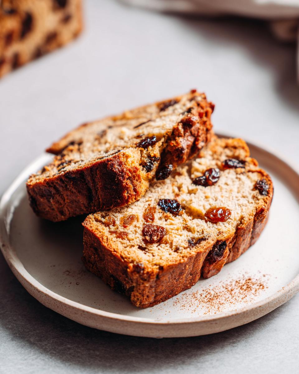 Two slices of Easter pudding desserts with raisins on a white plate.